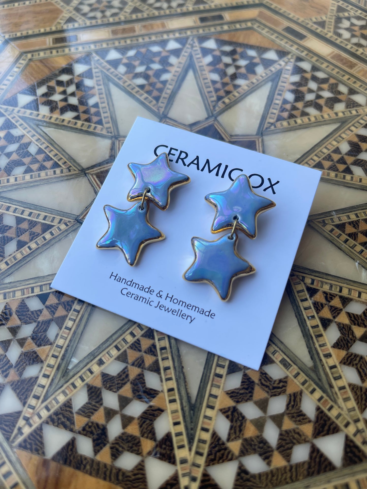 Iridescent double star dangle studs